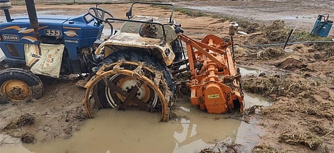 The wheels of a harvester stuck in the silt left behind by the receding flood waters symbolise the situation in Moranchapalle on Monday. (Photo | Express)