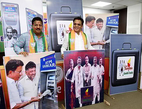BJP leader Dr CN Ashwath Narayan with posters targeting Congress leaders over corruption, in Bengaluru on Friday. (Photo | Express)