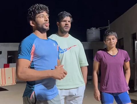 Wrestler Vishal Kaliraman (L) with his brother Krishan and Antim Panghal (R)