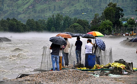 People stand on the bank of the swollen Beas river after heavy rainfall, in Kullu (Photo | PTI)
