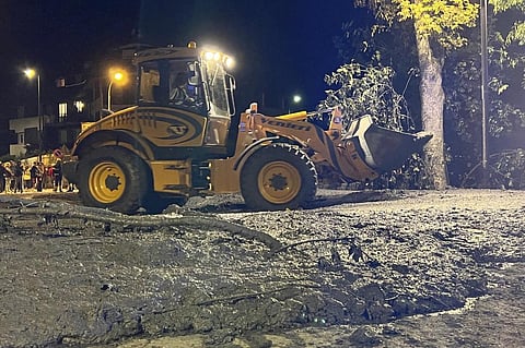 An excavator removes mud and debris following heavy storms, which caused the flooding of a stream in Bardonecchia, Northern Italy. (Photo | AP)