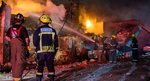 Firefighters work to extinguish a fire after an explosion in a commercial establishment in San Cristobal, Dominican Republic. (Photo | AFP)