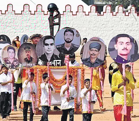 Students carry posters of martyrs of the Armed Forces, during the 77th Independence Day celebrations, at Manekshaw Parade Ground