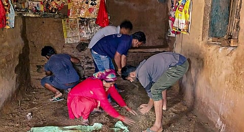 Residents engaged in clearing debris in a landslide affected village near Peepalkoti Bandh area of Uttarakhand. (Photo | PTI)