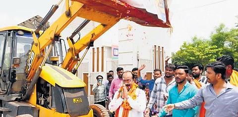 BJP state president Arun Sao greeted with flowers from bulldozer at party office. (Photo | Express)
