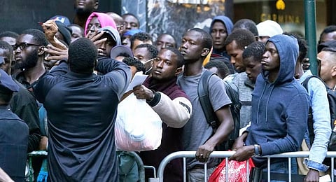 Hundreds of migrants line up early on August 1, 2023, for placement at the Roosevelt Hotel intake center in New York. (Photo | AFP)