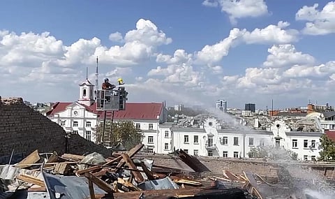 Firefighters work on a roof of the Taras Shevchenko Chernihiv Regional Academic Music and Drama Theatre damaged by Russian attack in Chernihiv, Ukraine. (Photo | AP)