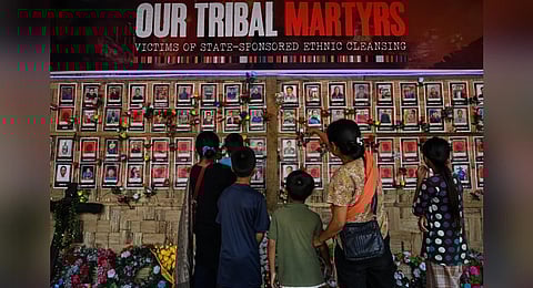 FILE - People look at portraits of victims who lost their lives during ethnic clashes, at a memorial in Churachandpur district in Manipur, July 24, 2023. (Photo | AFP)