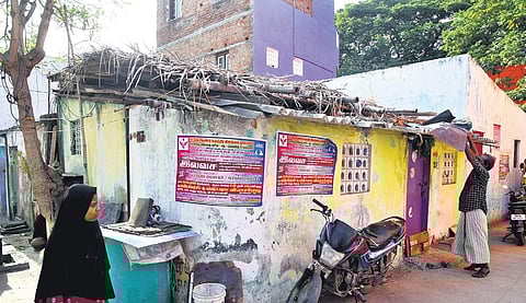 A resident repairs a damaged roof with a sheet at Vyrsarpadi | P Ravikumar