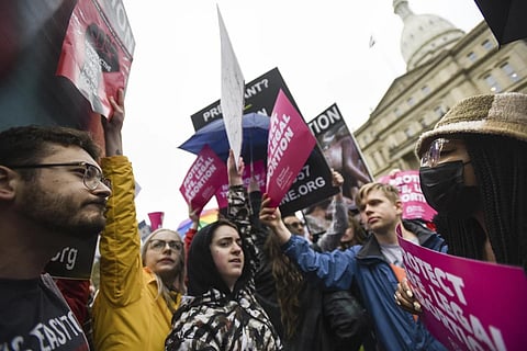 Abortion-rights advocates, right, try to block anti-abortion signage during a rally at the state capitol in Lansing, Mich., May 2, 2022. (Photo | AP)