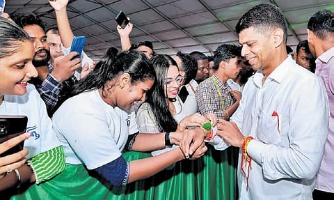A college student tying rakhi to 5T secretary VK Pandian’s wrist | Express