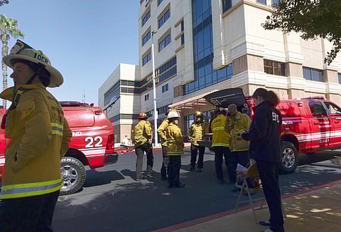 Los Angeles Fire Department people gather by the emergency entrance to the hospital. (Photo | AP)
