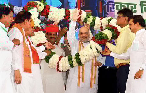 Union Home Minister Amit Shah being garlanded during 'Sahakar Kisan Sammelan' organised by IFFCO in Gangapur City, Rajasthan, Saturday, Aug 26, 2023. (Photo | PTI)