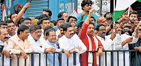 BJP leaders, including Nalin Kumar Kateel and R Ashoka, wait behind barricades to greet Prime Minister Narendra Modi in Bengaluru on Saturday. (Photo|Shashidhar Byrappa)