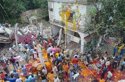People and security personnel gather after a blast at an illegal firecracker factory in which at least four people were killed and several others injured, in North 24 Parganas district. (PTI)