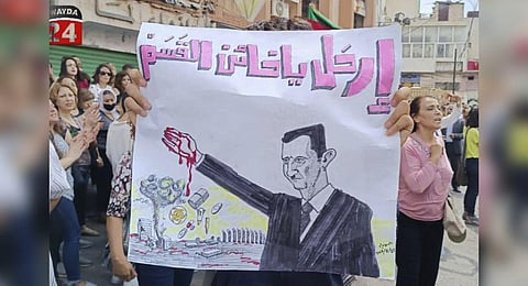 People stage a protest as they hold anti-Syrian President Bashar Assad placard that reads:' Get out, traitor to your oath,' in the southern city of Sweida, Syria, Monday, Aug 28, 2023. (Photo | AP)