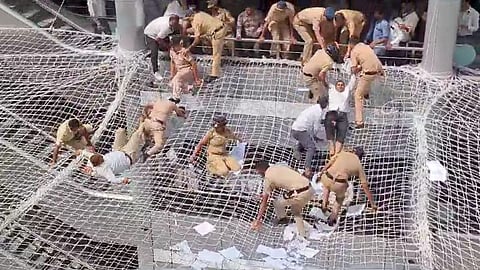 Cops pull back farmers who jumped on safety nets during a protest. (Photo | PTI)