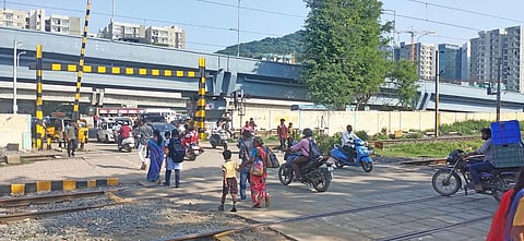 Motorists and pedestrains near the level-crossing gate at Perungalathur railway station. (Photo | Nasiya K J)
