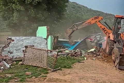 A bulldozer demolishes alleged illegal constructions after orders from the district administration, in Nuh district, Friday, Aug. 4, 2023. (Photo | PTI)