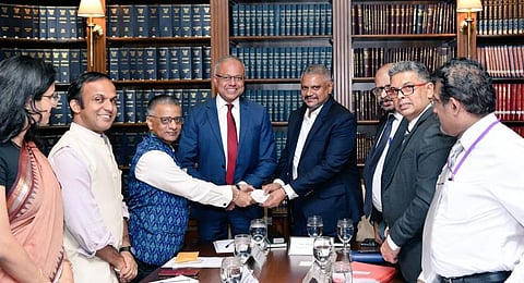 Indian High Commissioner Gopal Baglay hands over a cheque to Sri Lankan Minister Kanaka herath in Colombo. (Photo | Twitter @IndiainSL)