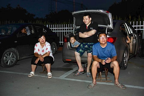 In this photo released by Xinhua News Agency, residents gather near their vehicles at an open space after an earthquake in Wangdagua of Pingyuan County, August 6, 2023. (Photo | AP)