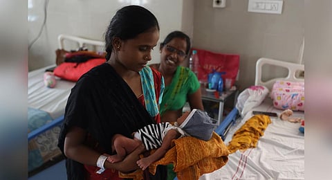 Meena, who underwent a C-section delivery at the King Koti Hospital in Hyderabad, holds her newborn on Monday.  (Photo | Sri Loganathan Velmurugan)
