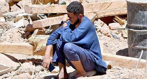 A man cries as he sits on the rubble of a house in the village of Tiksit, south of Adassil, on September 10, 2023.(Photo | AFP)