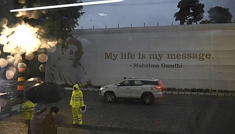 Security people seen standing guard at the rain-drenched Rajghat. (AP Images)