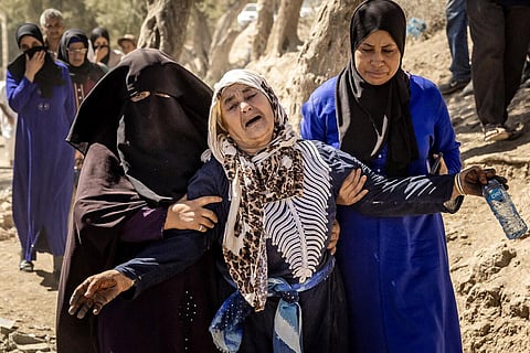 A woman is helped as she reacts to the death of relatives in an earthquake in the mountain village of Tafeghaghte, southwest of Marrakesh, on September 10, 2023. (AFP)