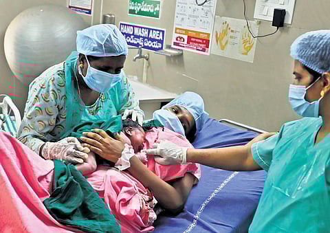 Swaroopa, a midwife from the first batch of the State, helps a newborn breast crawl after conducting the delivery at DH Khammam. (Photo | Sri Loganathan Velmurugan)
