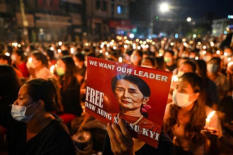 FILE - A protester holds a poster with an image of detained civilian leader Aung San Suu Kyi during a candlelight march against the military coup in Yangon on March 13, 2021. (Photo | AFP)