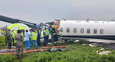 Officials gather around a damaged aircraft after it veered off the runway with six passengers and two crew members on board at the Mumbai airport amid heavy rains.(Photo | PTI)