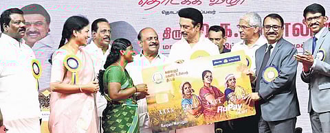 Chief Minister MK Stalin hands over the replica of an ATM card to a beneficiary to mark the launch of ‘Kalaignar Magalir Urimai Thittam’ in Kancheepuram on Friday.