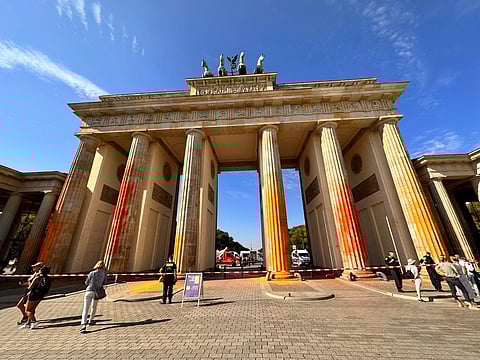 Members of the climate protection group Last Generation have sprayed the Brandenburg Gate with orange paint in Berlin. (Photo | AP)