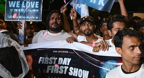 Fans of Indian actor Shahrukh Khan walk amidst confetti thrown in the air towards a movie theatre to watch the first show of Khan’s latest film - Jawan.(Photo | AFP)