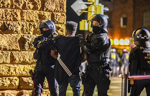 A man is taken away by police officers in Stuttgart, Baden-Württemberg, Germany, on Saturday, after clashes at a gathering of Eritrean groups. (Photo | AP)