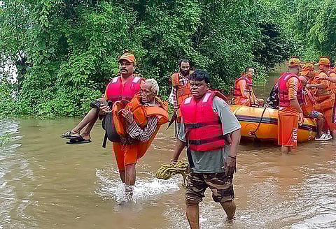 NDRF personnel rescue residents from a flooded area after heavy rains, in Narmada district. (Photo | PTI)