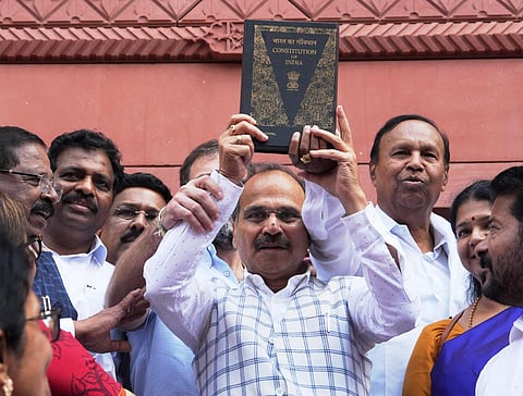 Congress MP Adhir Ranjan Chowdhury, holding a copy of the Constitution of India, walks towards the new Parliament building, in New Delhi, Tuesday, Sept. 19, 2023. (PTI)