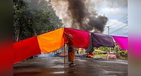A woman protester blocks a road during a 48-hour general strike in Imphal on Sept 19, 2023, as they demand restoration of peace in Manipur after ethnic violence. (Photo | AFP)