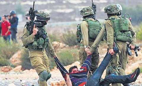 Israeli soldiers capture  a Palestinian protestor during a conflict