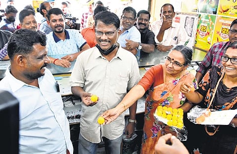 The staff and owner of Bava Lottery Agency distributing sweets after the lottery taken from the shop won the Onam bumper announced on Wednesday | Express