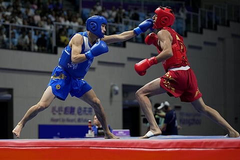 China's Xuetao Wang (L), fights Iran's Shoja Panahigelehkolaei in the Wushu men's 60kg final at 19th Asian Games in Hangzhou, China, Thursday, Sept. 28, 2023. (Photo | AP)