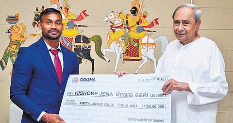 Chief Minister Naveen Patnaik presenting a cheque of `50 lakh to javelin thrower  Kishore Jena in Bhubaneswar on Saturday.