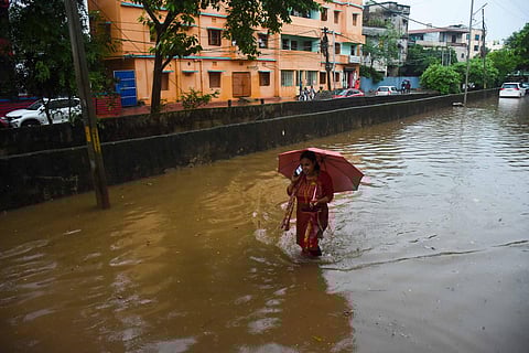A woman walks through a flooded lane near Bishnupriya Apartment at Jaydev Vihar in Bhubaneswar. (Photo | Debadatta Mallick)