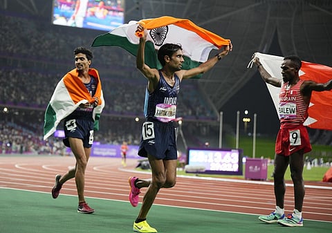 Bronze medalist Gulveer Singh (L) and silver medalist Kartik Kumar (C) celebrate after the men's 10000-meter final at the 19th Asian Games in Hangzhou, Sept. 30, 2023. (Photo | AP)