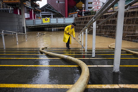 A worker clears water on a flooded street following heavy rainstorms in Hong Kong, Friday, Sept. 8, 2023. (Photo | AP)