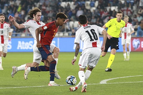Spain's Lamine Yamal, centre, challenges for the ball with Georgia's Luka Gagnidze, left, during the Euro 2024 group A qualifying soccer match between Georgia and Spain . (Photo | AP)