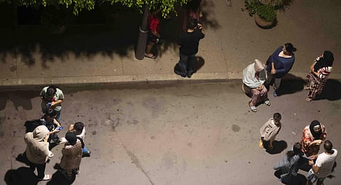 People take shelter and check for news on their mobile phones after an earthquake in Rabat, Morocco. (Photo | AP)