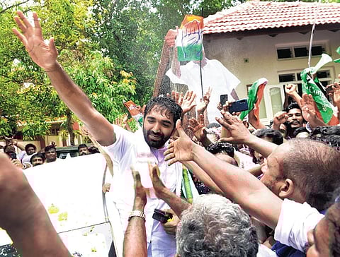 Chandy Oommen waving at supporters in front of Karottu Vallakkalil house at Puthuppally after the bypoll victory