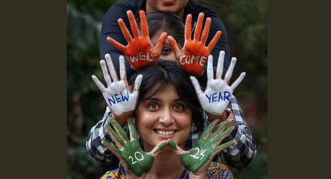 Youngsters with their hands painted in tricolour pose for  photographs, as celebrations to welcome 2024 break out on the eve of the New Year on the streets across the country on Sunday (PTI)